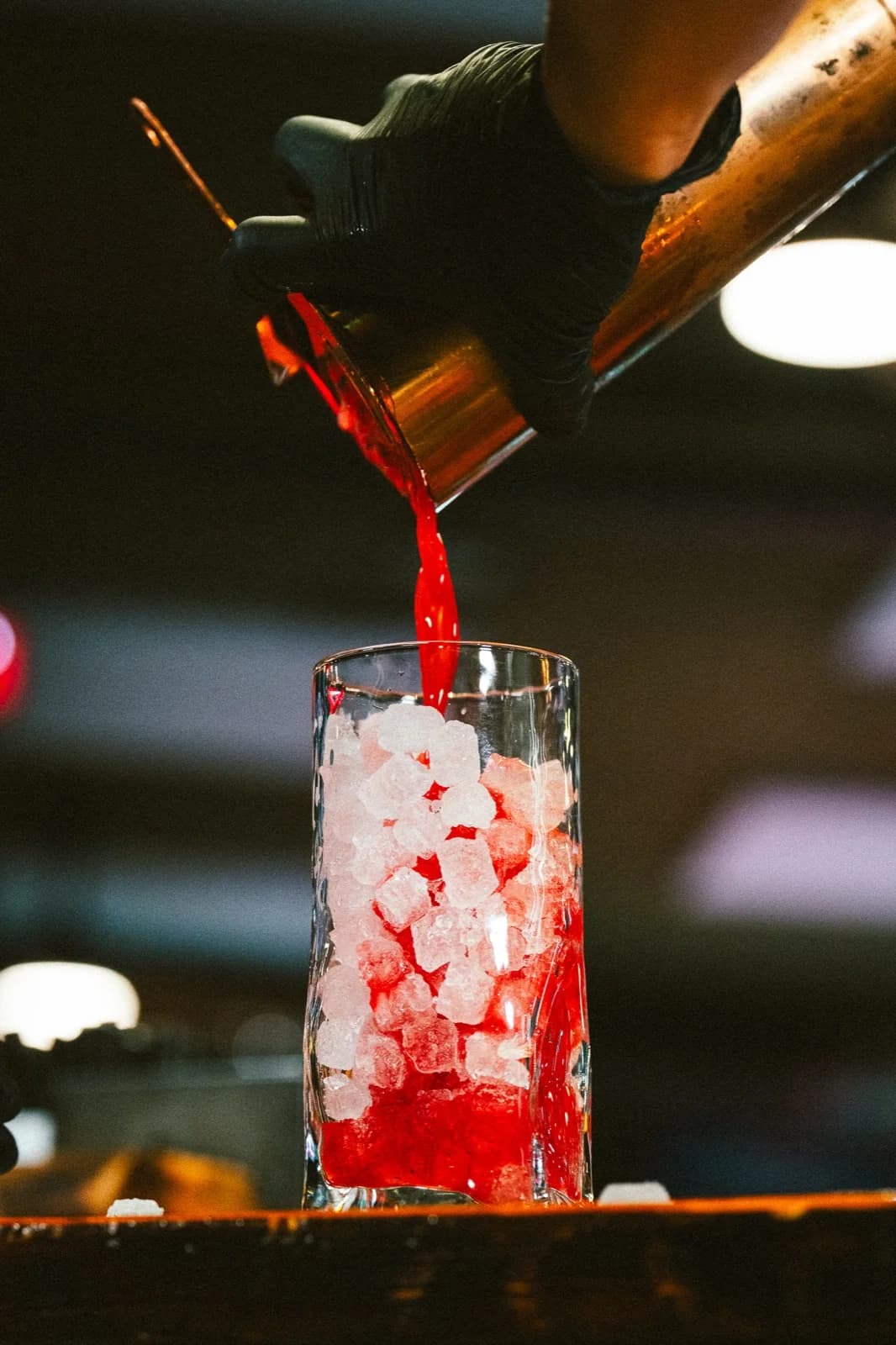 Bartender vertiendo cocktail rojo