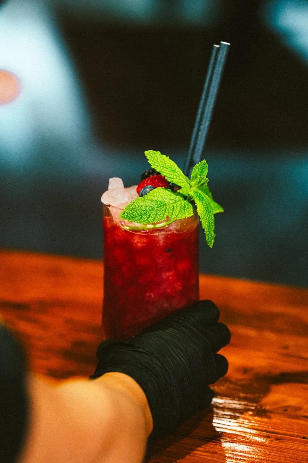 Cocktail rojo con frutos del bosque y menta en Singular Pub
