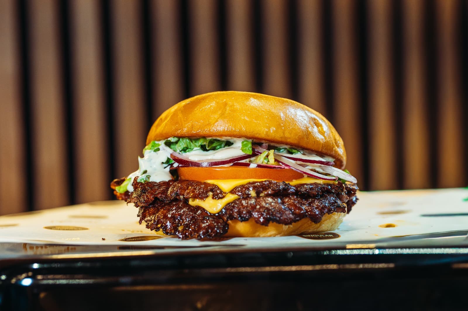 Singular Smash Burger con doble carne, queso fundido y cebolla morada